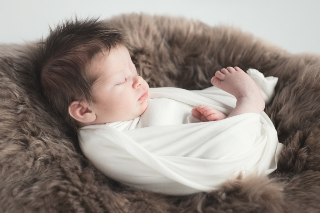 bébé emmailloté sur une peau douce